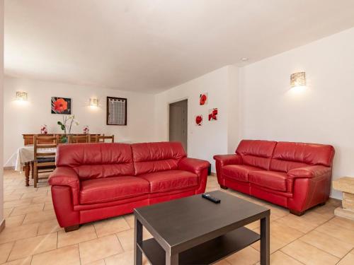 una sala de estar con 2 sofás rojos y una mesa. en Villa Kasara - MZN105 by Interhome en Mazan