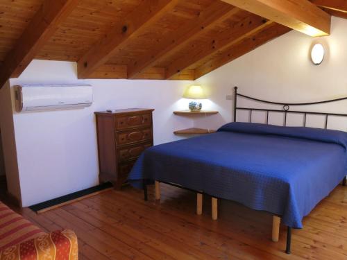 a bedroom with a blue bed and a wooden floor at Holiday Home Le Rose Rosse by Interhome in Grazzano Badoglio