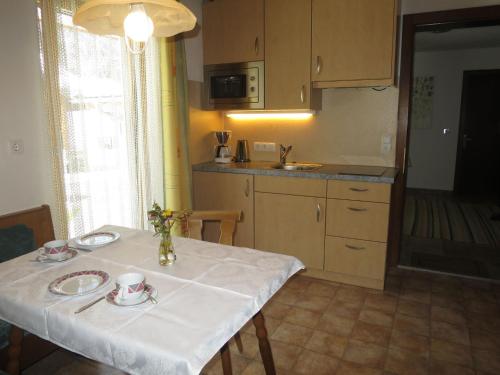 uma cozinha com uma mesa com uma toalha de mesa branca em Apartment Haus Mangard - GOP210 by Interhome em Sankt Gallenkirch