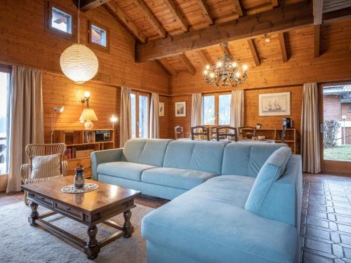 a living room with a blue couch and a table at Chalet Préplan by Interhome in Ovronnaz