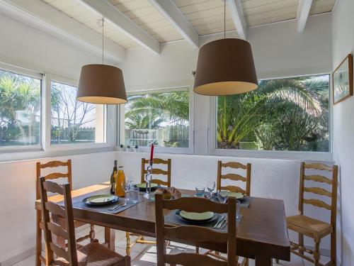 une salle à manger avec une table, des chaises et des fenêtres dans l'établissement Holiday Home Le Triskell by Interhome, à Cléder