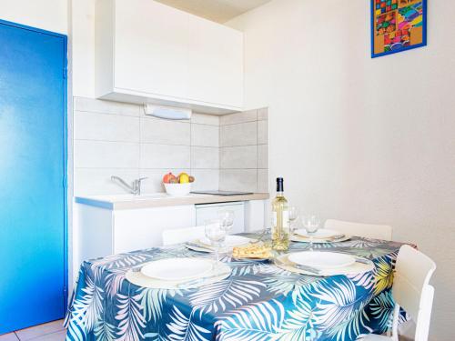 - une table à manger avec des assiettes et des verres à vin dans l'établissement Apartment Les Terrasses Fleuries by Interhome, à Saint Cyprien Plage