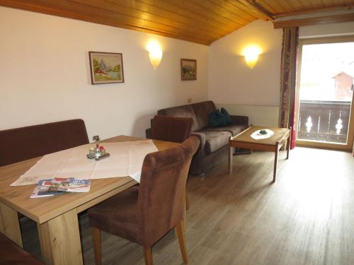 a living room with a table and a couch at Apartment Hof am Schönbach - STA161 by Interhome in Sankt Jakob