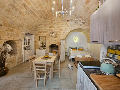 een keuken en een woonkamer met een tafel en een slaapkamer bij Dimora Il Pumo in Corato
