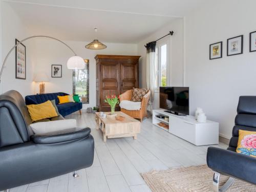 un salon avec deux canapés et une télévision dans l'établissement Holiday Home Les Cordylines by Interhome, à Anneville-sur-Mer