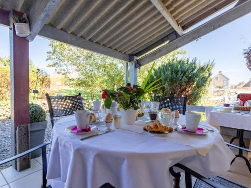 een tafel met een witte tafeldoek en voedsel erop bij Holiday Home La Batterie - LON400 by Interhome in Longues-sur-Mer