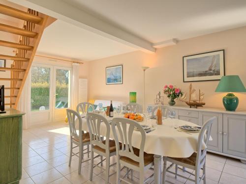 ein Esszimmer mit einem weißen Tisch und Stühlen in der Unterkunft Holiday Home Les Chênes Verts - LTB310 by Interhome in La Turballe