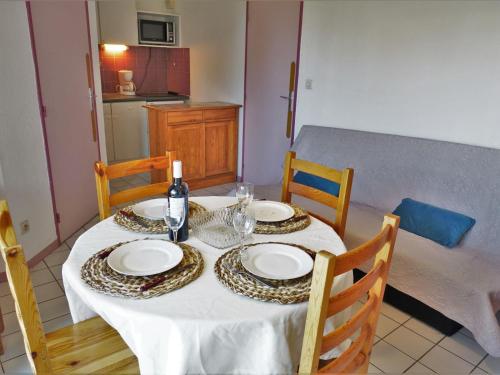 une table à manger avec une nappe blanche et deux chaises dans l'établissement Apartment Les Cigalines-1 by Interhome, à Narbonne-Plage