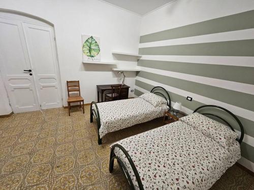 um quarto com 2 camas e uma parede listrada em Cà Tosca em La Spezia