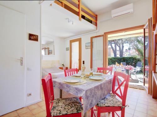 une salle à manger avec une table et des chaises rouges dans l'établissement Holiday Home Le Hameau du Rivage-6 by Interhome, à Saint Cyprien Plage