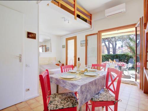 サン・シプリアン・プラージュにあるHoliday Home Le Hameau du Rivage by Interhomeのダイニングルーム(テーブル、赤い椅子付)