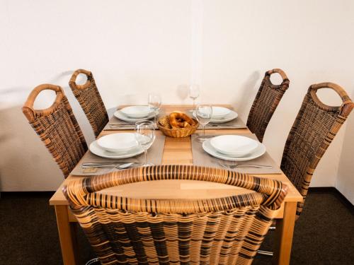 - une table en bois avec des chaises et un panier de verres à vin dans l'établissement Apartment F 112 by Interhome, à Dittishausen