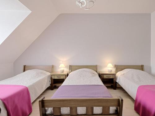 three beds in a room with pink and white sheets at Holiday Home Le Clos Er Bert by Interhome in Sarzeau