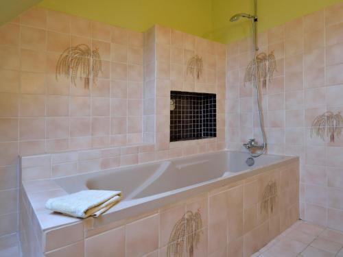 a bathroom with a tub with a towel on it at Holiday Home Le Clos Er Bert by Interhome in Sarzeau