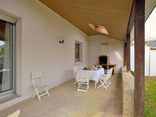 a patio with a table and chairs and a fireplace at Holiday Home Le Clos Er Bert by Interhome in Sarzeau