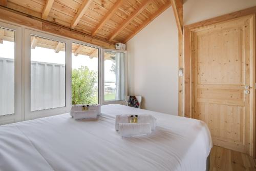 a bedroom with a large white bed with two boxes on it at Villa Mimbeau in Cap-Ferret