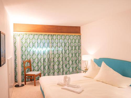 Un dormitorio con una cama con una toalla. en Apartment Chesa La Sajetta by Interhome en Surlej