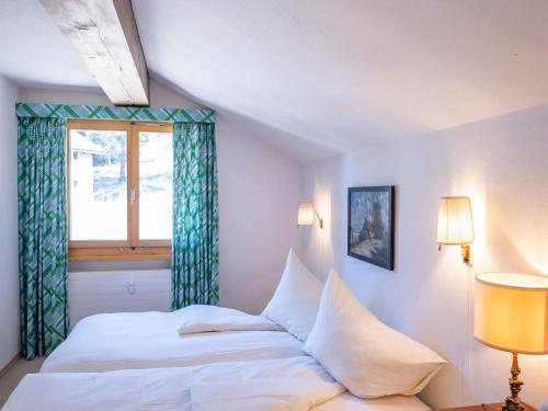 1 dormitorio con cama blanca y ventana en Apartment Chesa La Sajetta by Interhome en Surlej