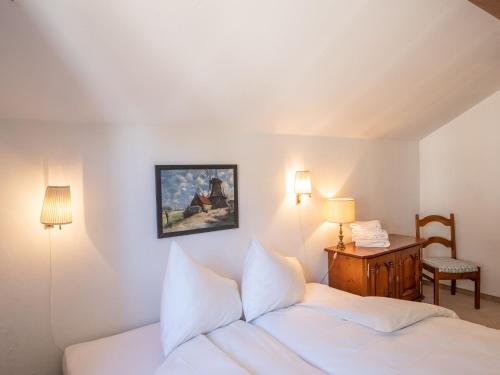 a bedroom with a bed and a desk with a chair at Apartment Chesa La Sajetta 12 by Interhome in Surlej
