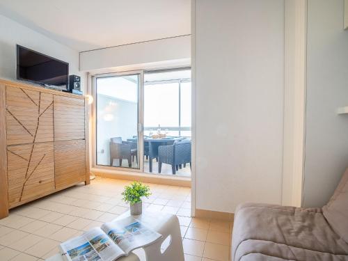 a living room with a couch and a table at Apartment Les Trois Mâts-4 by Interhome in Canet-en-Roussillon