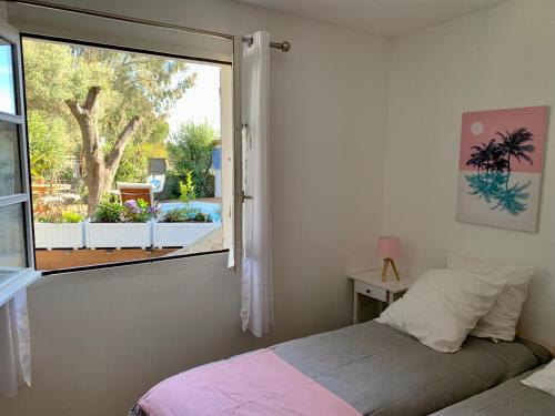- une chambre avec une fenêtre donnant sur un jardin dans l'établissement La villa Flamingo toute proche de la plage, à Biguglia