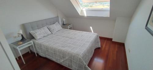 Apartamento Aldán - Vilariño في كانجاس دي مورازو: غرفة نوم صغيرة بها سرير ونور