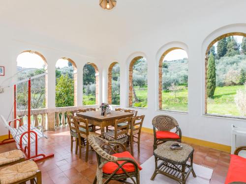 Cette chambre comprend une table, des chaises et des fenêtres. dans l'établissement Holiday Home Podere Casina by Interhome, à Sinalunga
