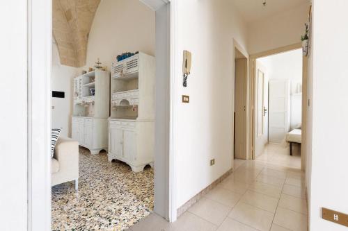 a kitchen with white cabinets and a rug at Casa della Sabina by BarbarHouse in Maruggio