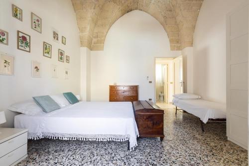 ein Schlafzimmer mit einem großen weißen Bett und einer Kommode in der Unterkunft Casa della Sabina by BarbarHouse in Maruggio