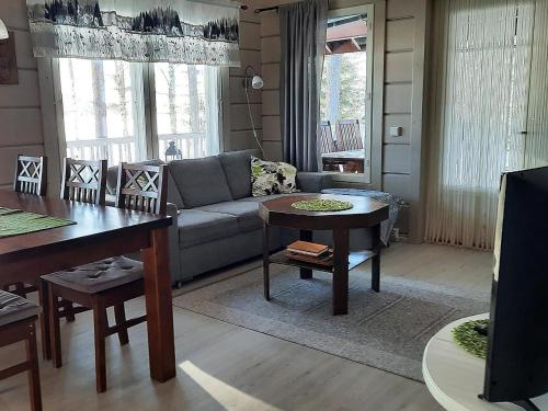 ein Wohnzimmer mit einem Sofa und einem Tisch in der Unterkunft Holiday Home Loisteranta by Interhome in Vääräkoski