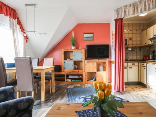 eine Küche und ein Esszimmer mit einer orangefarbenen Wand in der Unterkunft Apartment Vinnenhuis-1 by Interhome in Duhnen