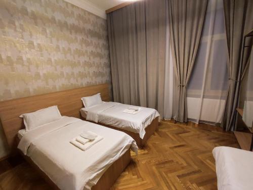 a hotel room with two beds and a window at Cozy Apartment In Old Town Kutaisi in Kutaisi