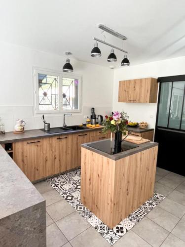 - une cuisine avec un îlot au milieu d'une pièce dans l'établissement Maison en lisière de forêt, à Mios