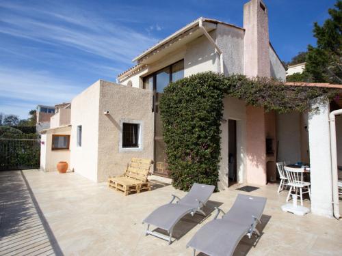 eine Terrasse eines Hauses mit Stühlen und einem Tisch in der Unterkunft Holiday Home Le Belvédère by Interhome in Saint-Clair