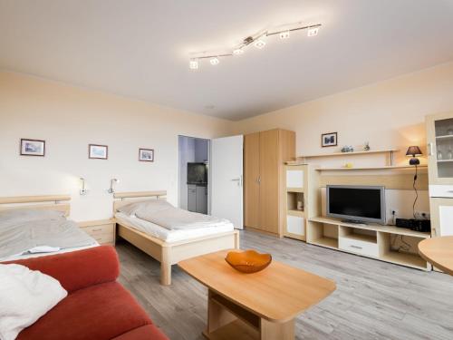 ラーンシュタインにあるApartment B806 by Interhomeのベッド、ソファ、テレビが備わる客室です。