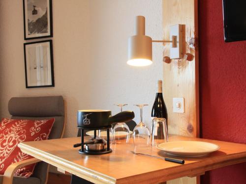 una mesa con una botella de vino y una lámpara en Studio Le Bristol B36 by Interhome, en Villars-sur-Ollon