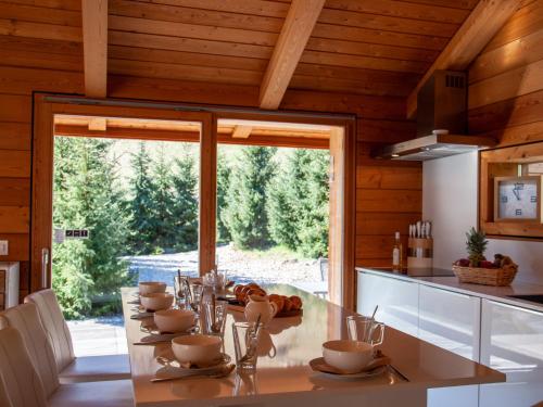 cocina con mesa y ventana grande en Chalet Papillon by Interhome, en Nendaz