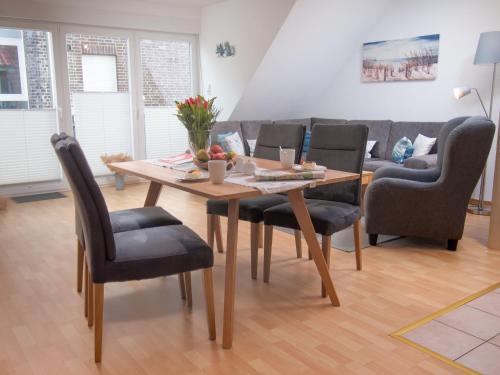 einen Tisch und Stühle im Wohnzimmer mit Sofa in der Unterkunft Apartment Seegras by Interhome in Norddeich