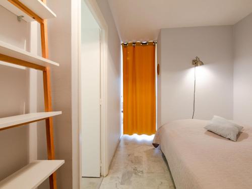 - une chambre avec un lit et un rideau orange dans l'établissement Studio Résidence Azur-3 by Interhome, à Sainte-Maxime