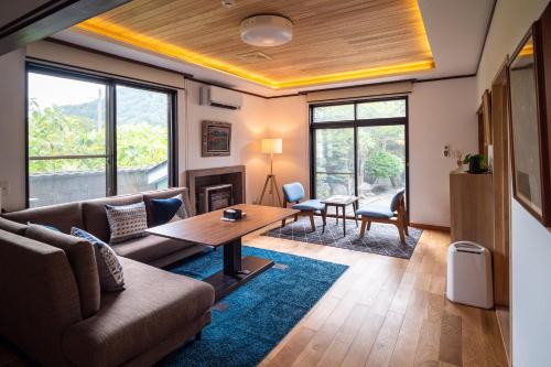a living room with a couch and a table at Immaculate Private Family Cottage with Hot Spring in Towada