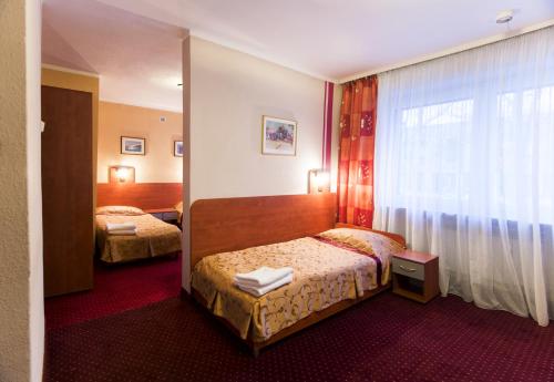 a hotel room with two beds and a window at Hotel Orion in Sosnowiec