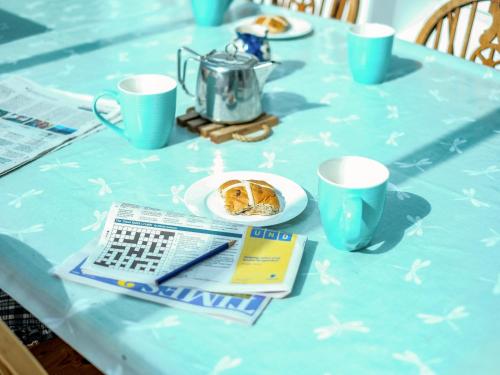 a table with a blue table cloth with a plate of food at Boskewys in Wadebridge