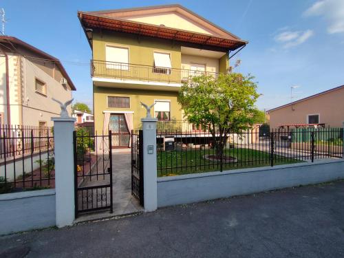 ein gelbes Haus mit einem Tor und einem Baum in der Unterkunft Le Aquile in Ghedi