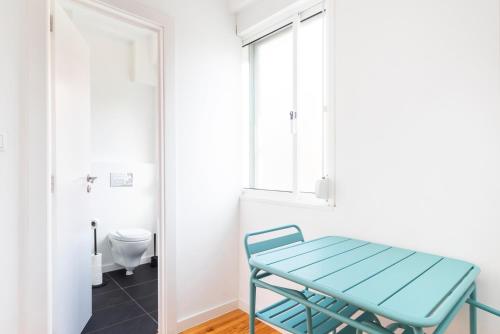 une table bleue dans une salle de bains avec toilettes dans l'établissement Gloria 10, à Lisbonne