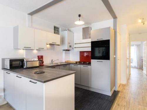 une cuisine avec des armoires blanches et un comptoir dans l'établissement Apartment Poséidon by Interhome, à Arcachon