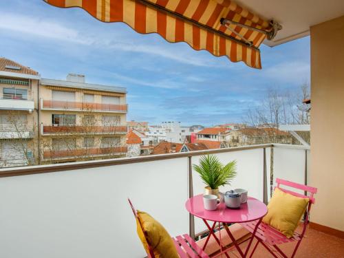 balkon z różowym stołem i krzesłami w obiekcie Apartment Poséidon by Interhome w Arcachon