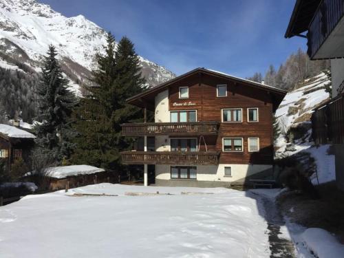 a large wooden house with a balcony in the snow at Apartment Cresta di Saas by Interhome in Saas-Grund