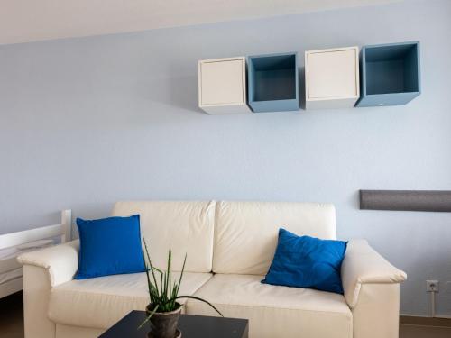 sala de estar con sofá blanco y almohadas azules en Apartment B 110 by Interhome, en Dittishausen