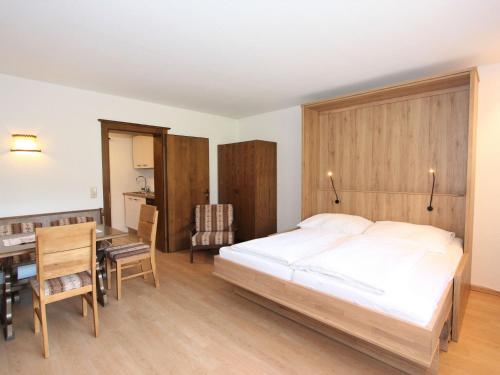 1 dormitorio con cama, escritorio y mesa en Apartment Römerhof-5 by Interhome en Fügen