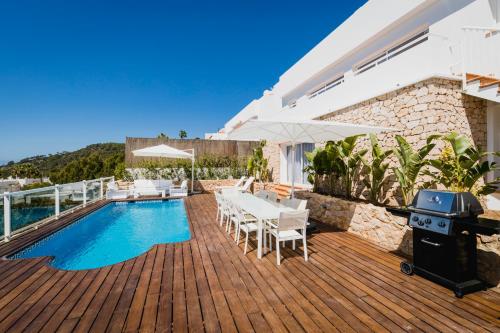 a patio with a table and chairs next to a swimming pool at Villa Serretes in Cala Vadella
